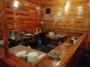 a kitchen with wooden walls and a counter with plates at The Peak Ella in Ella