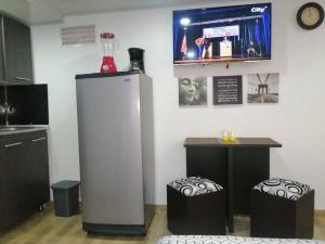 uma cozinha com um frigorífico e 2 bancos em Apartaestudio tipo LOFT INDEPENDIENTE em Bogotá
