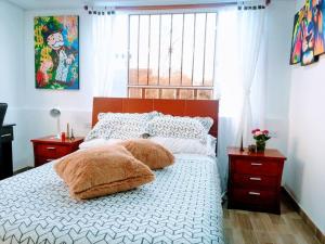 a bedroom with a bed with two pillows on it at Apartaestudio tipo LOFT INDEPENDIENTE in Bogotá