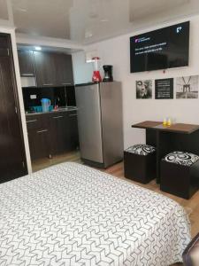 1 dormitorio con 1 cama y cocina con TV en Apartaestudio tipo LOFT INDEPENDIENTE, en Bogotá