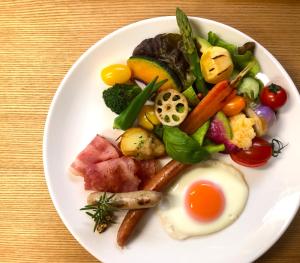 a plate of food with an egg and vegetables at B&B Kumakara in Kamakura