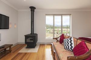 a living room with a couch and a wood stove at Grampians Manor House in Halls Gap