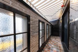 an empty hallway with windows and a brick wall at ARA Hotel in Seoul