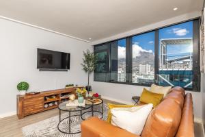 a living room with a couch and a table at Beautiful Family Apartment with amazing views @ 16 on Bree in Cape Town