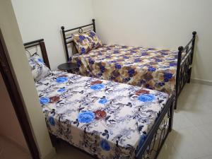 a bedroom with two beds with blue and white covers at Appartement à louer Tiznit 1 in Tiznit