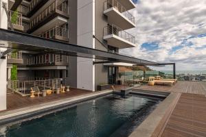 a building with a swimming pool in front of a building at Beautiful Family Apartment with amazing views @ 16 on Bree in Cape Town