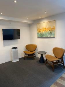 a waiting room with two chairs and a flat screen tv at V Hotel Johor Bahru in Johor Bahru