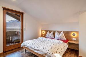 ein Schlafzimmer mit einem Bett und einem großen Fenster in der Unterkunft Kammerhof Apartment Apfel in Lana