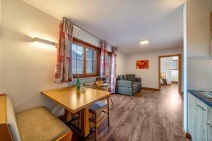 eine Küche und ein Wohnzimmer mit einem Tisch und einem Sofa in der Unterkunft Kammerhof Apartment Apfel in Lana