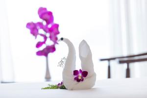 a white statue of a white swan and purple flowers at Miracle Luxury Nha Trang in Nha Trang