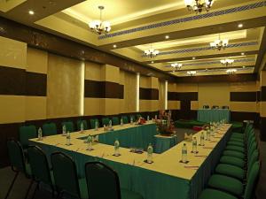 einen Konferenzraum mit einem langen Tisch und grünen Stühlen in der Unterkunft Renest Tirupati in Tirupati