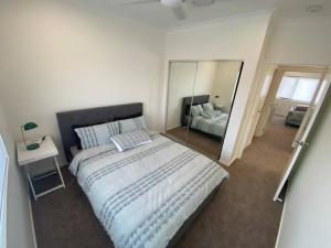 - une chambre avec un grand lit et un miroir dans l'établissement Relax Stay - Close to River in Hope Island, à Gold Coast