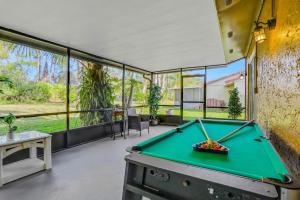 a pool table in the middle of a room with windows at Wildflower Haven in Orlando