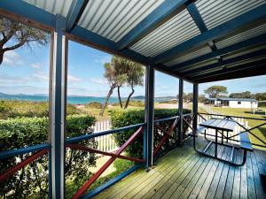 a view from the porch of a house with a bench on a deck at Acclaim Rose Gardens Beachside Holiday Park in Albany