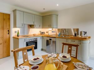 a kitchen with white cabinets and a wooden table at Middle Mistal in Stainburn