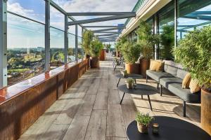 a rooftop patio with couches and tables and plants at The Den, 's-Hertogenbosch, a Tribute Portfolio Hotel in Den Bosch