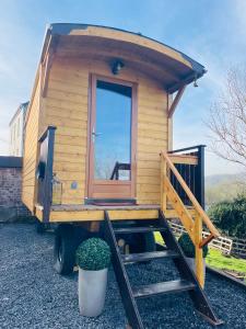 a tiny house with a porch on a trailer at La Rouloulotte in Durbuy