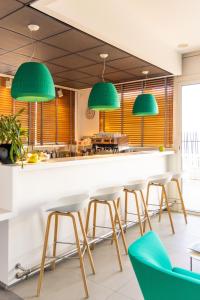 a kitchen with green pendant lights above a counter at Hôtel Riva Art & Spa in Menton