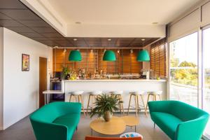 a restaurant with green chairs and a bar at Hôtel Riva Art & Spa in Menton
