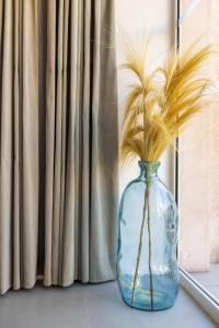 a blue vase with feathers in it next to a window at Hôtel Riva Art & Spa in Menton