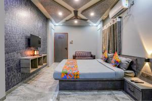 1 dormitorio con 1 cama y TV. en FabHotel Viva House en Pune