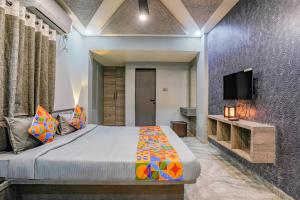 1 dormitorio con 1 cama y TV en la pared en FabHotel Viva House, en Pune