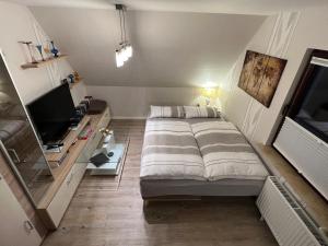 シュターデにあるPeedy's luxuriöse 60m² Wohnung mit Balkonterrasseの小さなベッドルーム(ベッド1台、テレビ付)