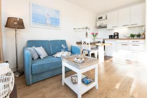 uma sala de estar com um sofá azul e uma mesa em Haus Baltic Wohnung 20 em Scharbeutz