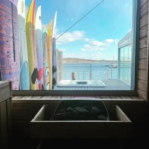 a kitchen sink with a view of a window with surfboards at Seehaus Pippa mit Sauna and Whirlpool direkt am See in Mücheln