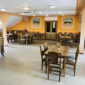 une salle à manger avec des tables et des chaises en bois dans l'établissement Cserki Panzió Balatonfőkajár, à Balatonfőkajár