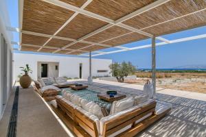 une terrasse avec des canapés, une table et une piscine dans l'établissement Villa Lámpsi - Spacious & modern, à Isterni