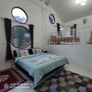 a bedroom with a bed and two windows at บ้านชายดอย Glamping ดอยแม่แจ๋ม cheason ,Muangpan, Lampang in Ban Mai