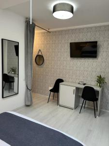 a bedroom with a desk and two chairs and a bed at Pensiunea Max in Cluj-Napoca