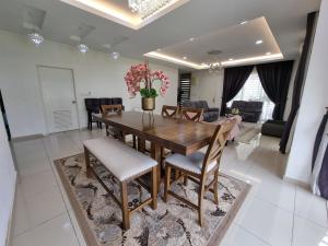 a dining room with a wooden table and chairs at Aluha Homestay Sendayan with Swimming Pool in Labu