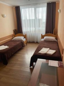 una camera d'albergo con due letti e una finestra di Готель "Дубно" a Dubno