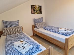2 Betten in einem Zimmer mit blauer und weißer Bettwäsche in der Unterkunft Haus Bergler in Blaichach