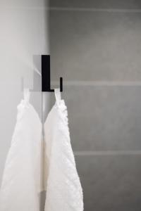 two white dresses are hanging on a wall at Hôtel Riva Art & Spa in Menton