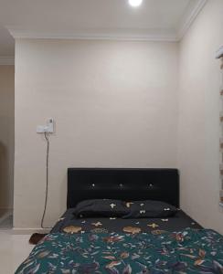 um quarto com uma cama com uma cabeceira preta em HOMESTAY BY ZIKRY em Kota