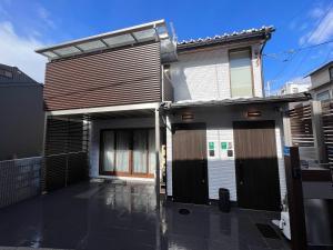 une maison avec des portes noires sur son côté dans l'établissement Platinum.Kiyomizu, à Giommachi