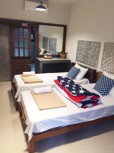 a room with two beds with towels on them at Suandok History House in Chiang Mai