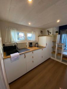 a kitchen with white cabinets and a counter top at Tiny House Stever im PIER9 Tiny House Hotel in Hamm