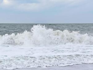 a wave in the ocean on a beach at 9 person holiday home in Harbo re in Harboør