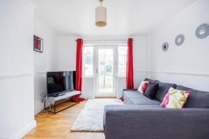 ein Wohnzimmer mit Sofa und Fernseher in der Unterkunft 6 Bedroom Larger group House with Parking Corringham Stanford Le Hope in Horndon on the Hill