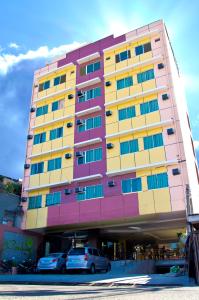 um edifício colorido com carros estacionados em frente em Canberry Hotel em Cebu