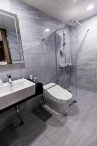 a bathroom with a toilet and a sink and a shower at Ashton Hotel in Ulsan
