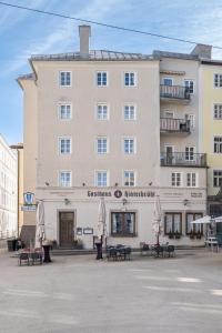 un gran edificio con sombrillas delante en Gasthaus Hinterbrühl, en Salzburgo