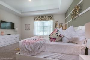 a bedroom with a bed with pillows and a television at Solara Resort - 5 Bed 4,5 Baths TOWNHOME in Orlando