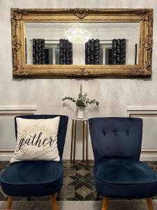 a mirror and two blue chairs and a pillow at SalutBB Chambre d'hote in Carcassonne