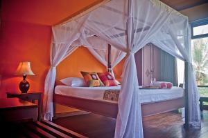 1 dormitorio con 1 cama con dosel en Villa Ma'Rasai en Ternate