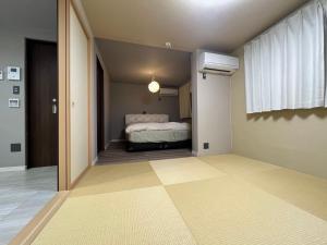 ein Schlafzimmer mit einem Bett in einem Zimmer mit Flur in der Unterkunft Platinum.Kiyomizu in Giommachi